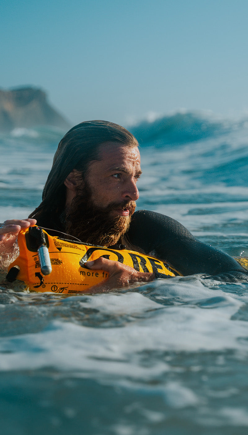 Surfer in rough seas with RESTUBE buoy – focused and confident thanks to reliable buoyancy in the waves.