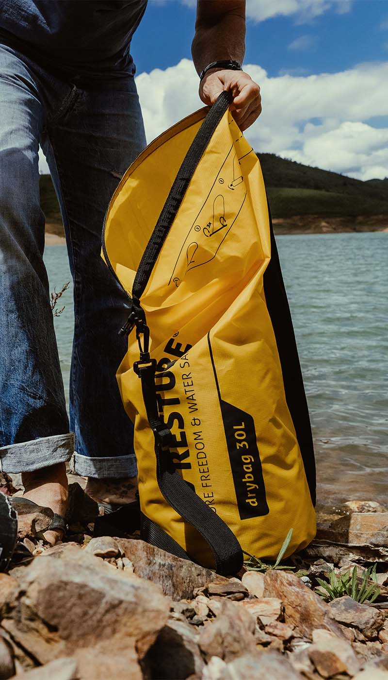 RESTUBE Drybag 30L being opened by the lake – waterproof gear designed for carefree adventures.