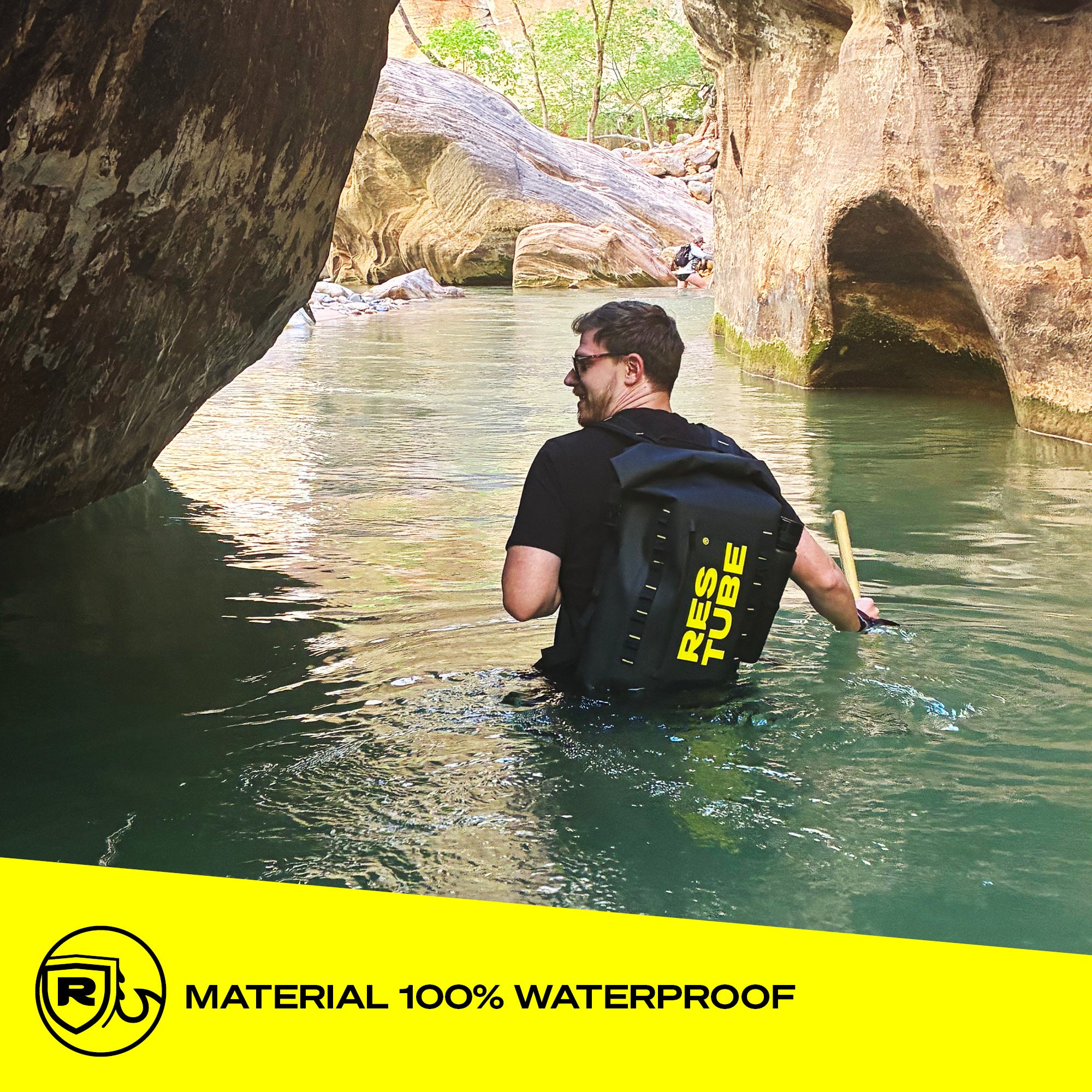 Man wading through a canyon river wearing the RESTUBE COAST backpack – 100% waterproof material