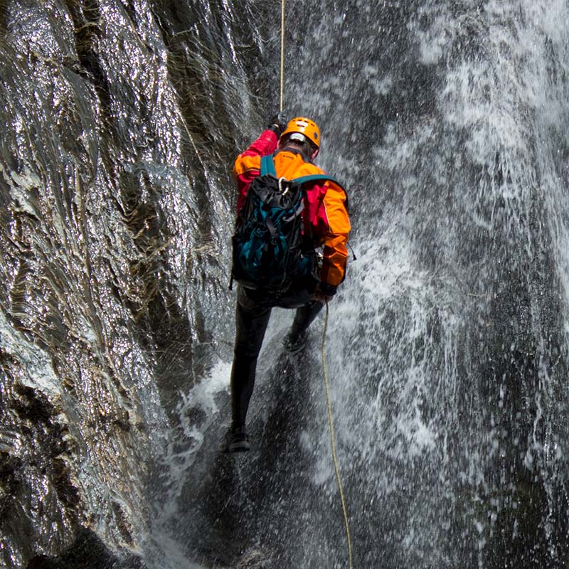 Climber with RESTUBE safety buoy at a waterfall.