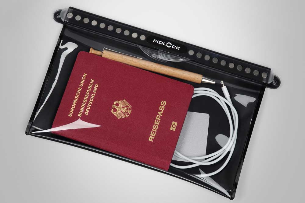 A waterproof pouch with a passport, a wooden pen, and some cables – ideal for safe travel.