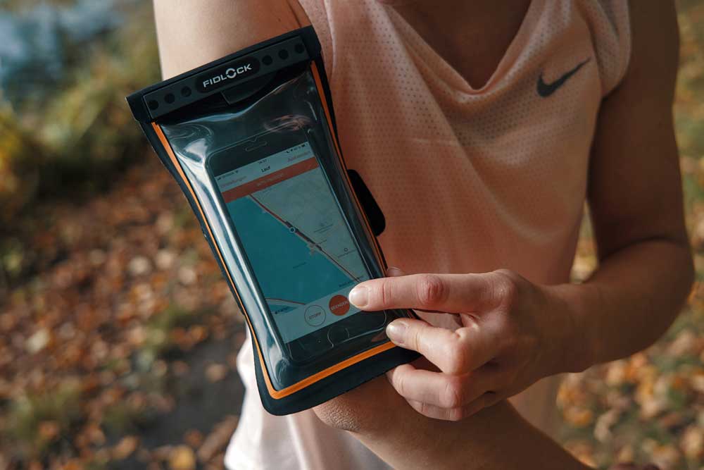 Waterproof phone case on runner’s arm outdoors.