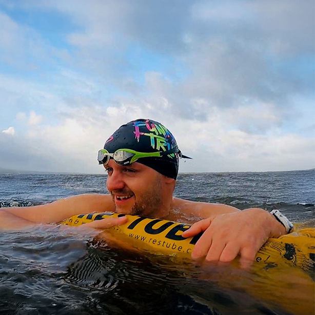 A swimmer with RESTUBE safety buoy in open water – for enhanced safety and visibility.