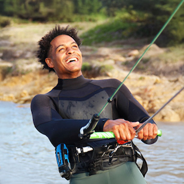 Kitesurfer with RESTUBE buoy on belt, smiling on the water.