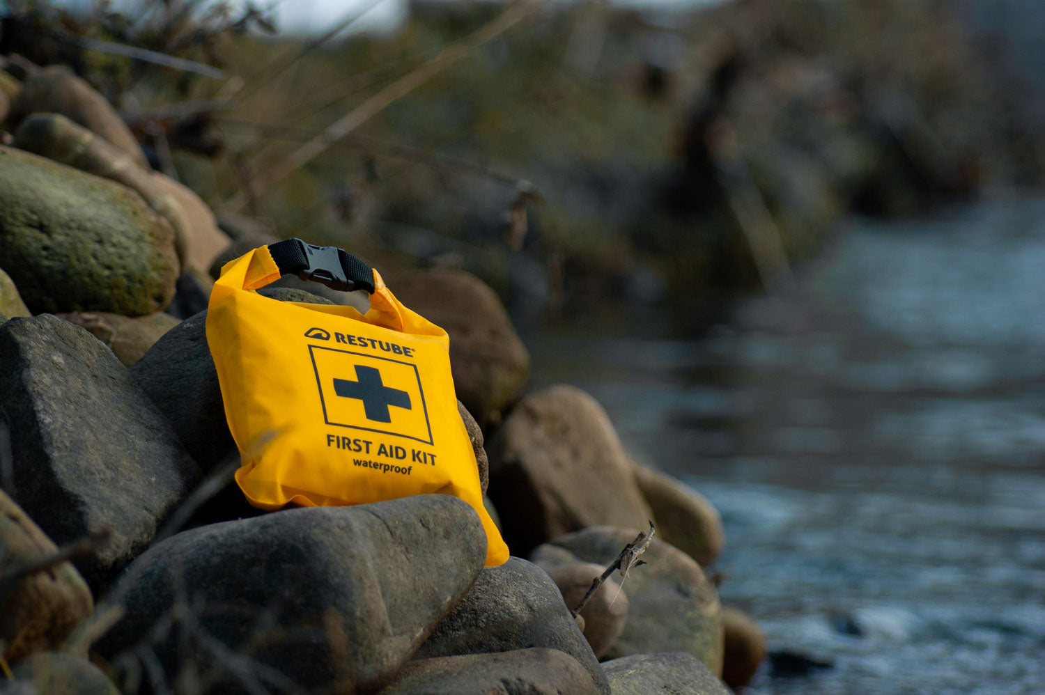 Aid Kit between Rocks at the edge of a river in winter