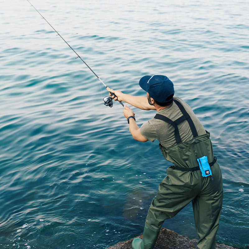 Angler with RESTUBE buoy on his belt while fishing by the water.