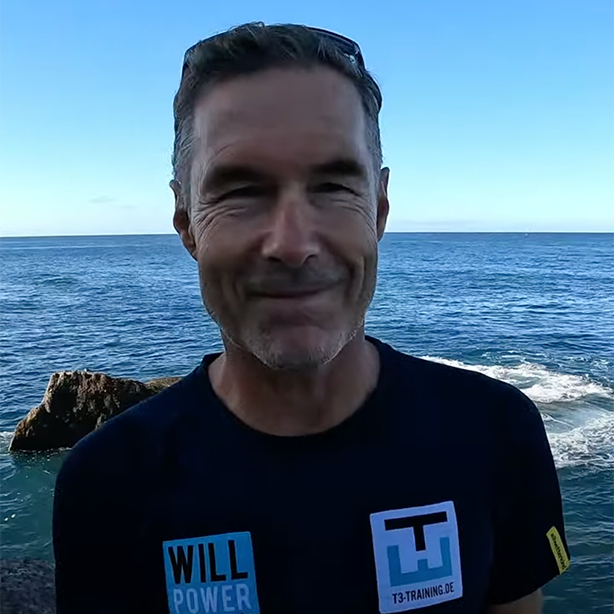 Coach Holger at the beach in a dark-blue T-shirt – experienced open-water trainer who trusts RESTUBE to give athletes more confidence in Atlantic swim training.