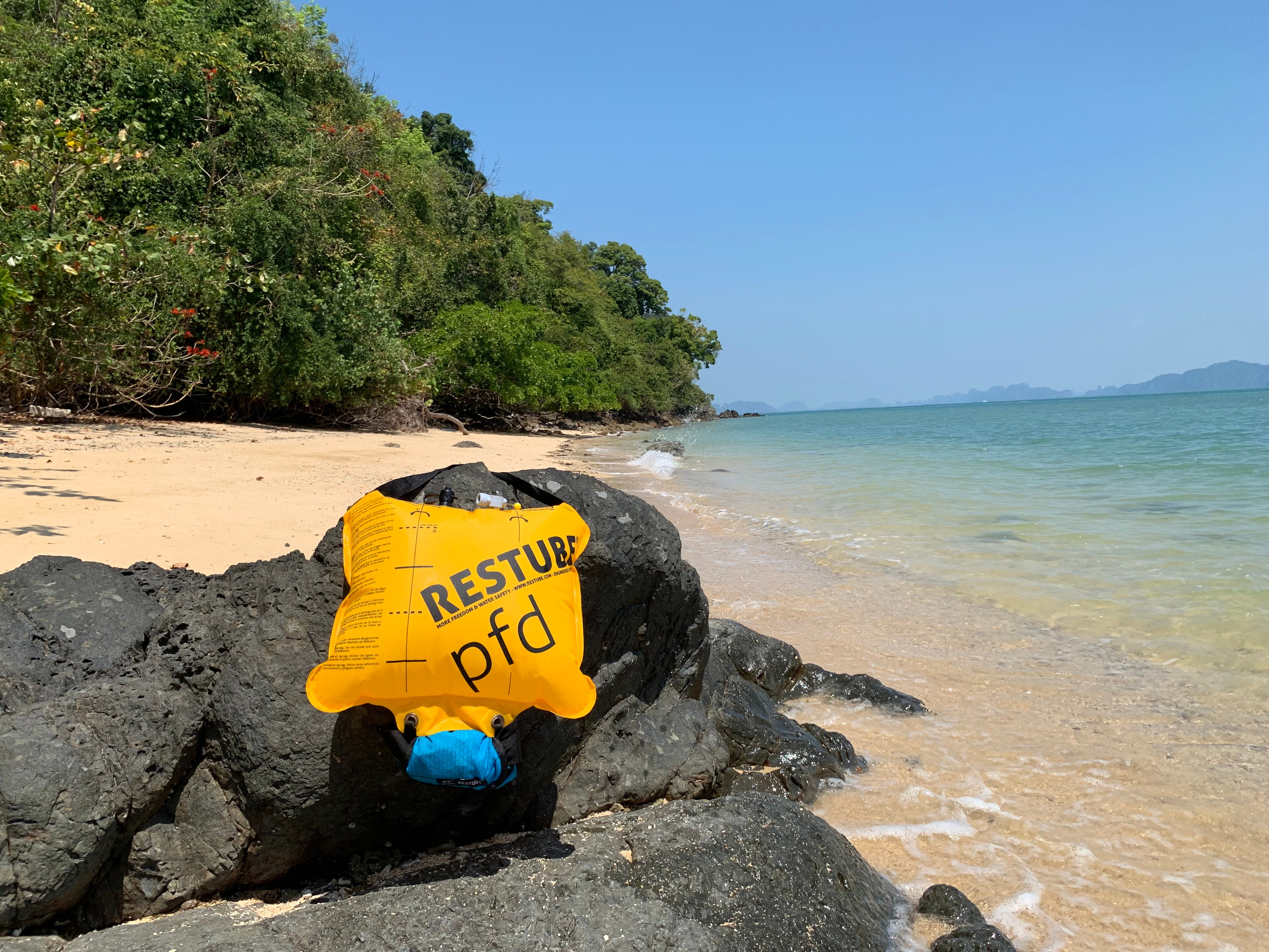 RESTUBE PFD on rocky beach – for water safety and visibility.