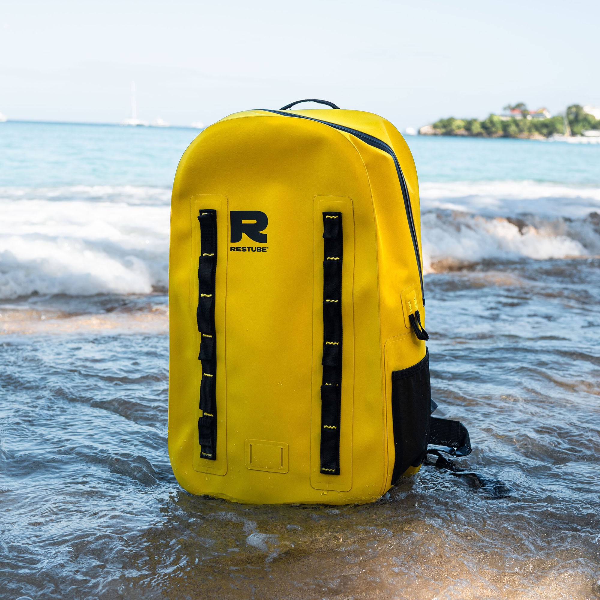 Yellow RESTUBE waterproof backpack standing in the ocean, designed for outdoor and water adventures with secure storage and modular attachment points