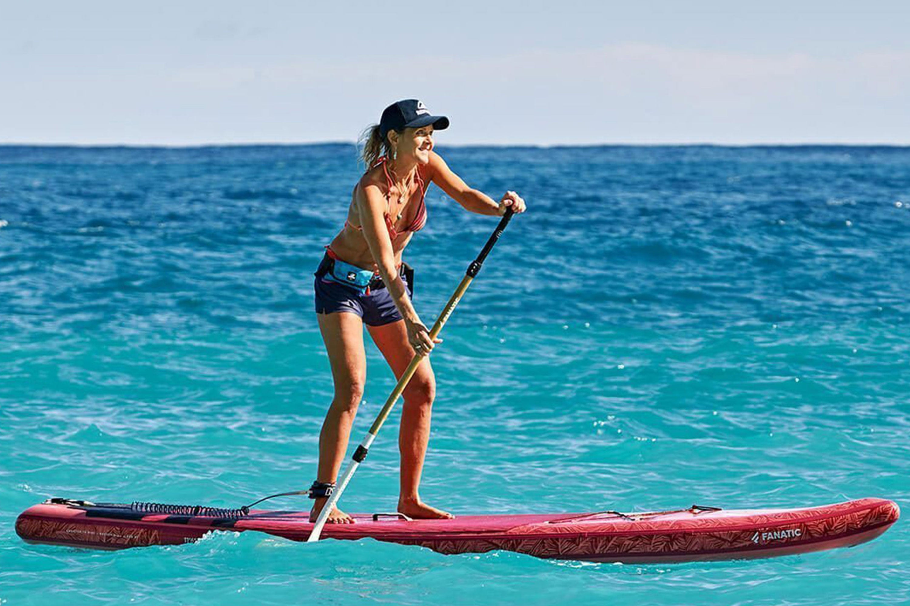 Woman stand-up paddling with RESTUBE buoy – for safety on the sea.