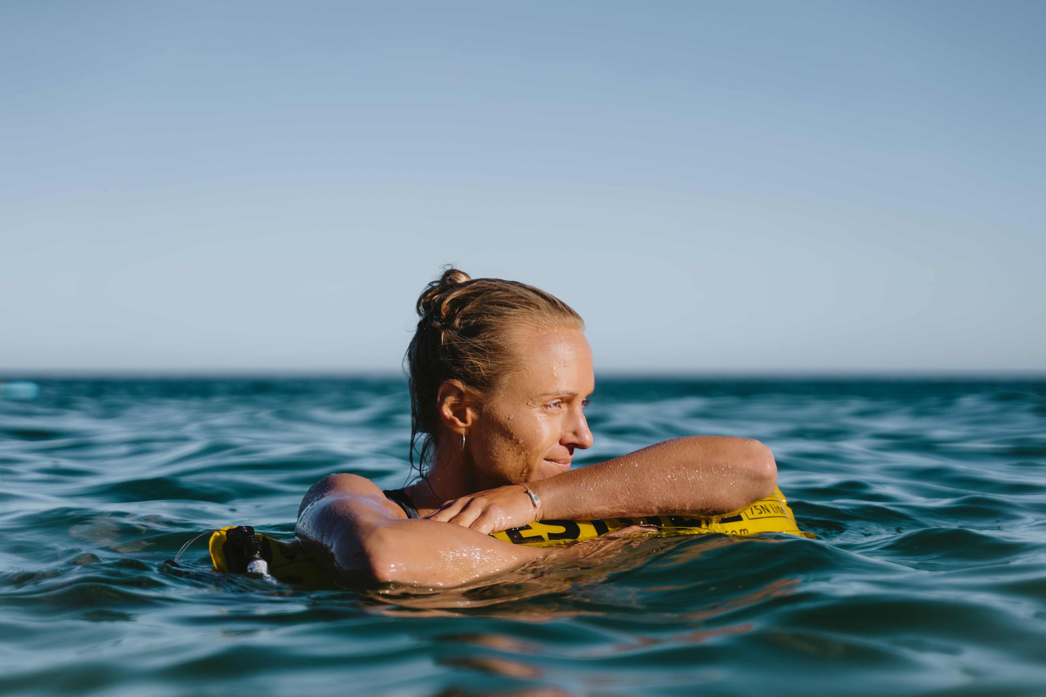 A female swimmer with RESTUBE safety buoy in the sea – for safety and buoyancy.
