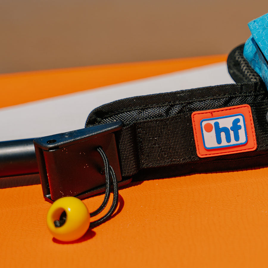 Close-up of RESTUBE safety buoy with ripcord on orange background.