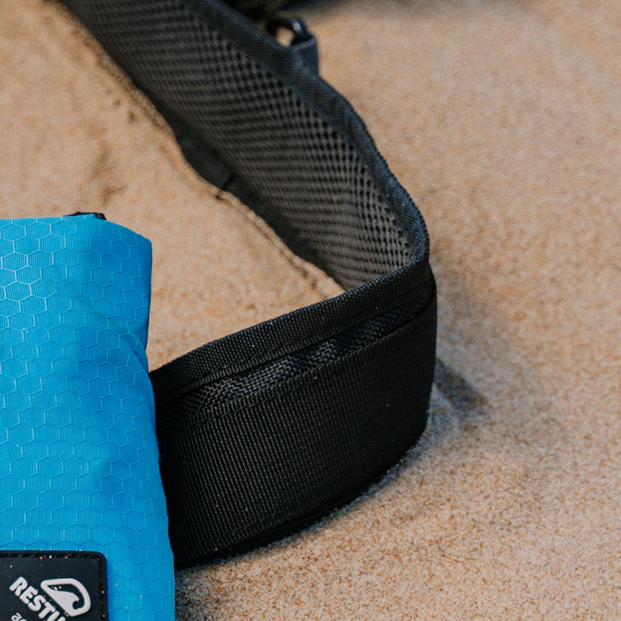 A close up of an inflatable RESTUBE safety buoy on the beach in the sand.