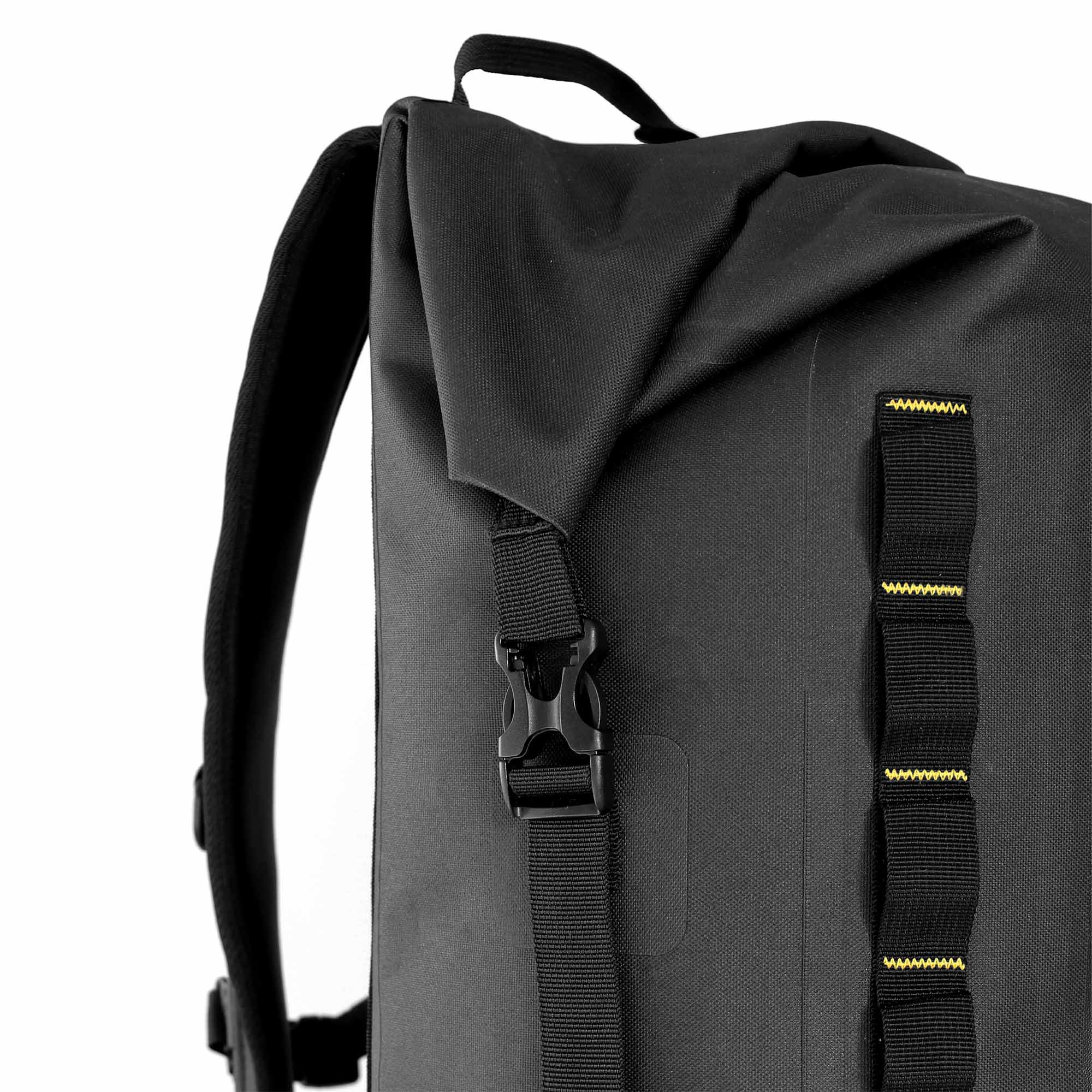 Close-up of roll-top closure with buckle fastening and front attachment loops on black waterproof backpack