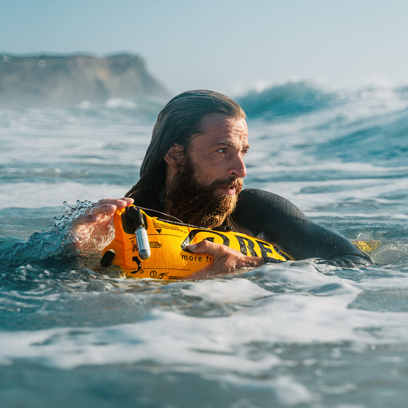 Surfer in the ocean with RESTUBE buoy – for flotation and confidence.