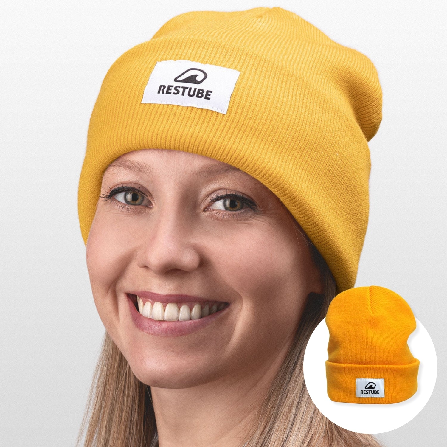 Yellow RESTUBE beanie with logo, worn by a smiling person.