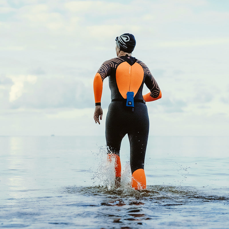 Swimmer with RESTUBE buoy in a wetsuit in the sea – symbolizes water safety and freedom.