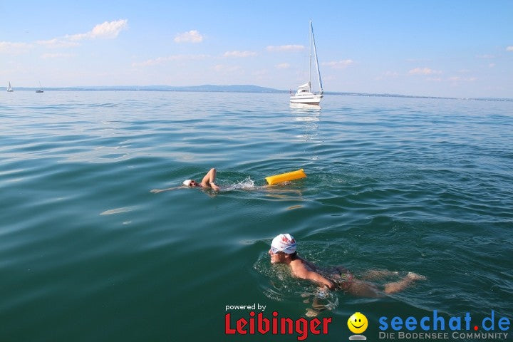 One swimmer with RESTUBE buoy  and another without in Lake Constance – with a sailboat in the background.