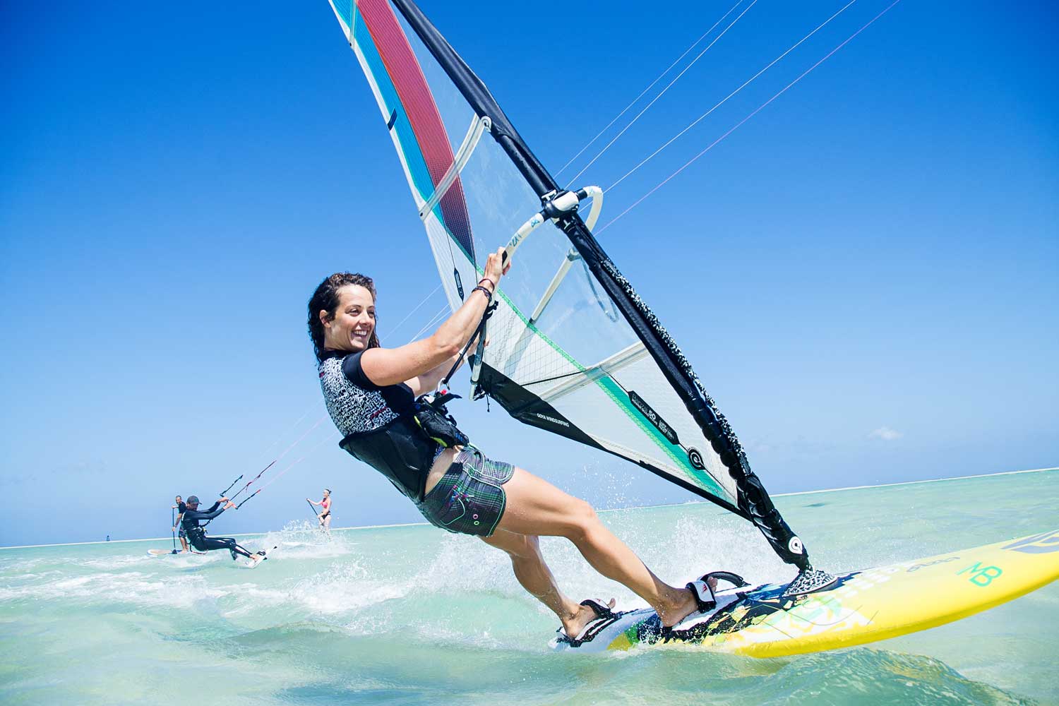 Mehrere Wind- und Kite-Surfer gleiten über das Wasser
