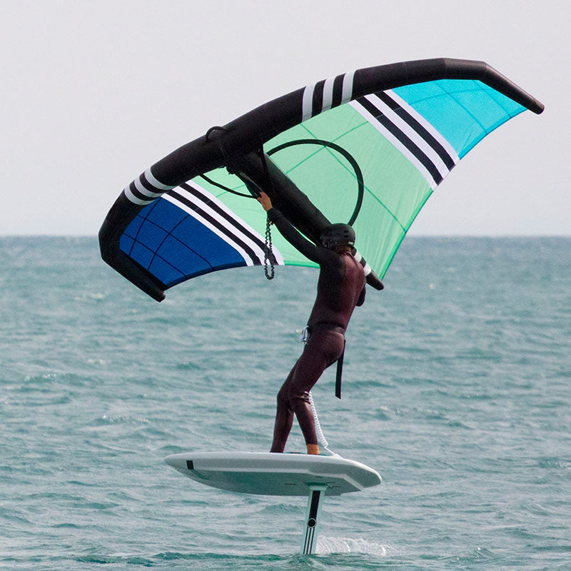 Watersports athlete with wingfoil and RESTUBE buoy on the ocean.