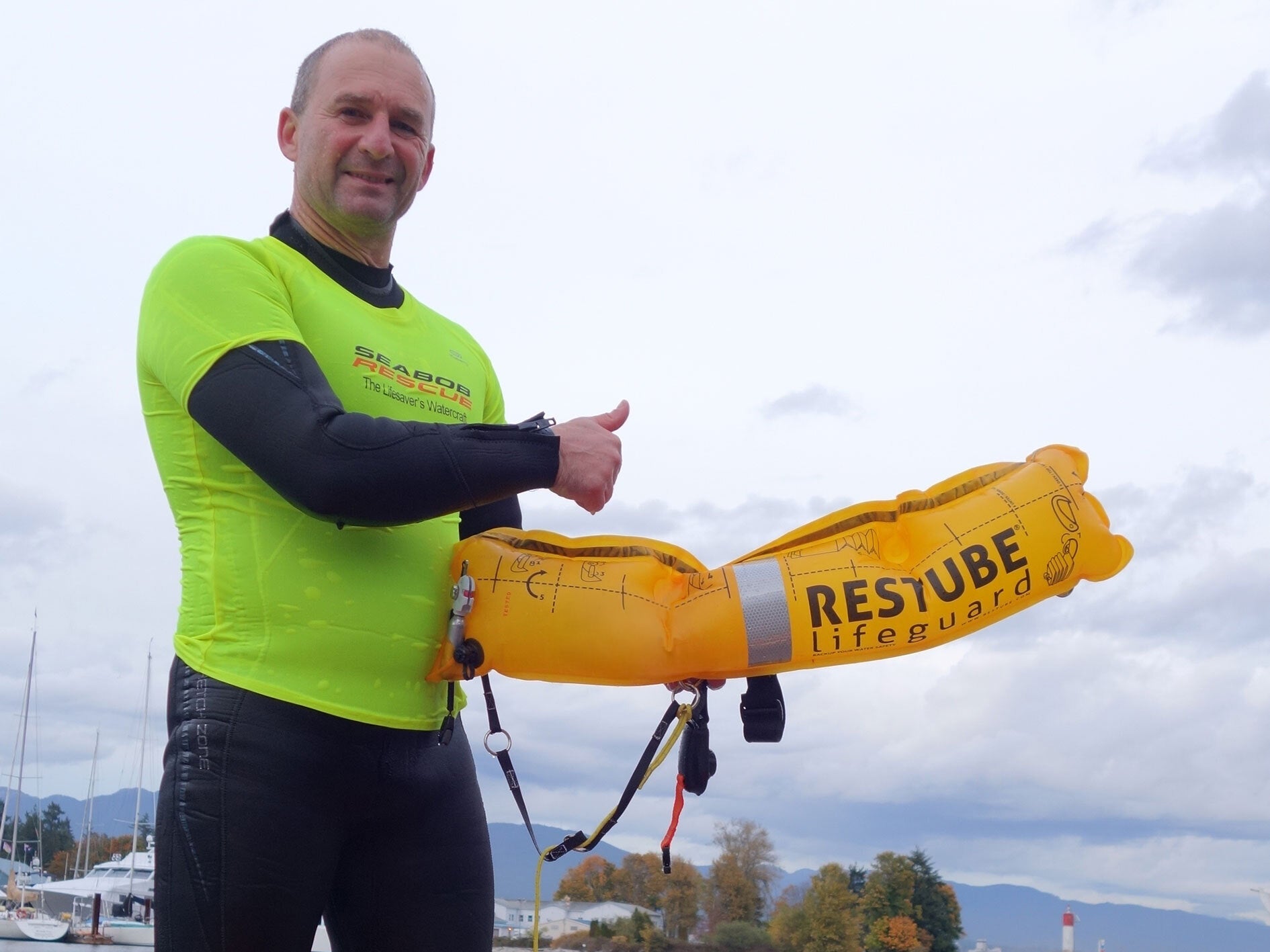 Lifeguard with RESTUBE Lifeguard buoy by the water.
