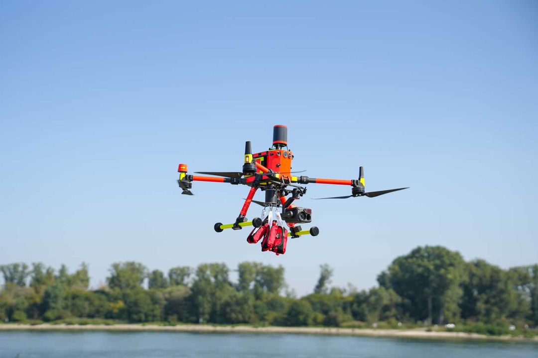 Drone with the RESTUBE buoys above a river – deployed for water safety.