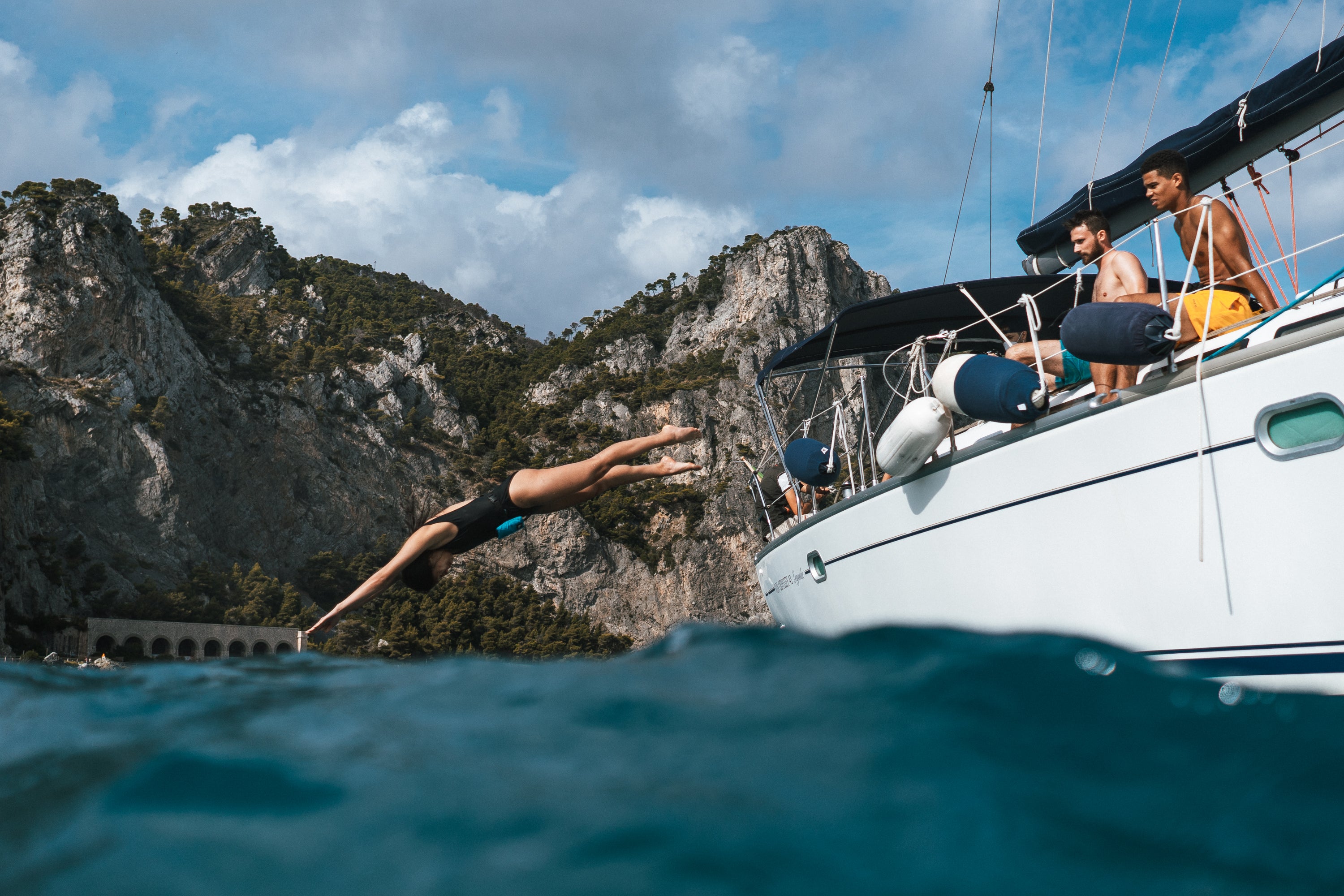 Frau springt einen Kopfsprung vom Boot ins Meer und hat eine Restube active dabei.