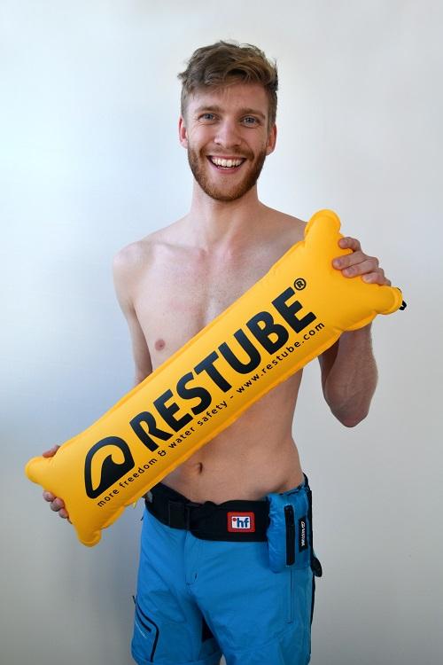 Mann mit hf Gürtel und aufgeblasener Restube Boje