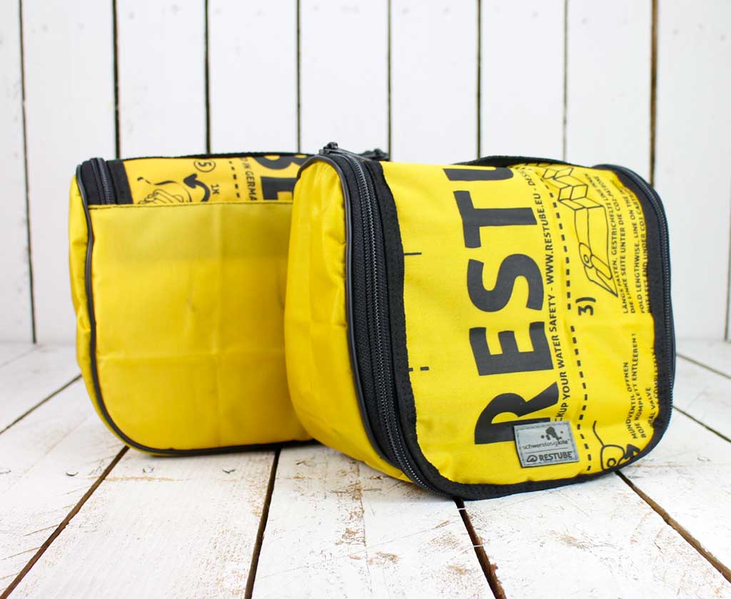 Zwei Waschtaschen gelb und schwarz von Restube und Schwerelosigkite aus recycelten Restube Schwimmbojen, eine von vorn, die andere von hinten