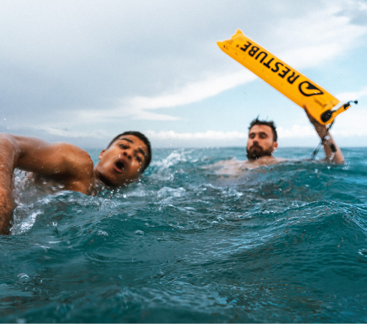 Schwimmer hilft anderem mit einer Restube Schwimmboje