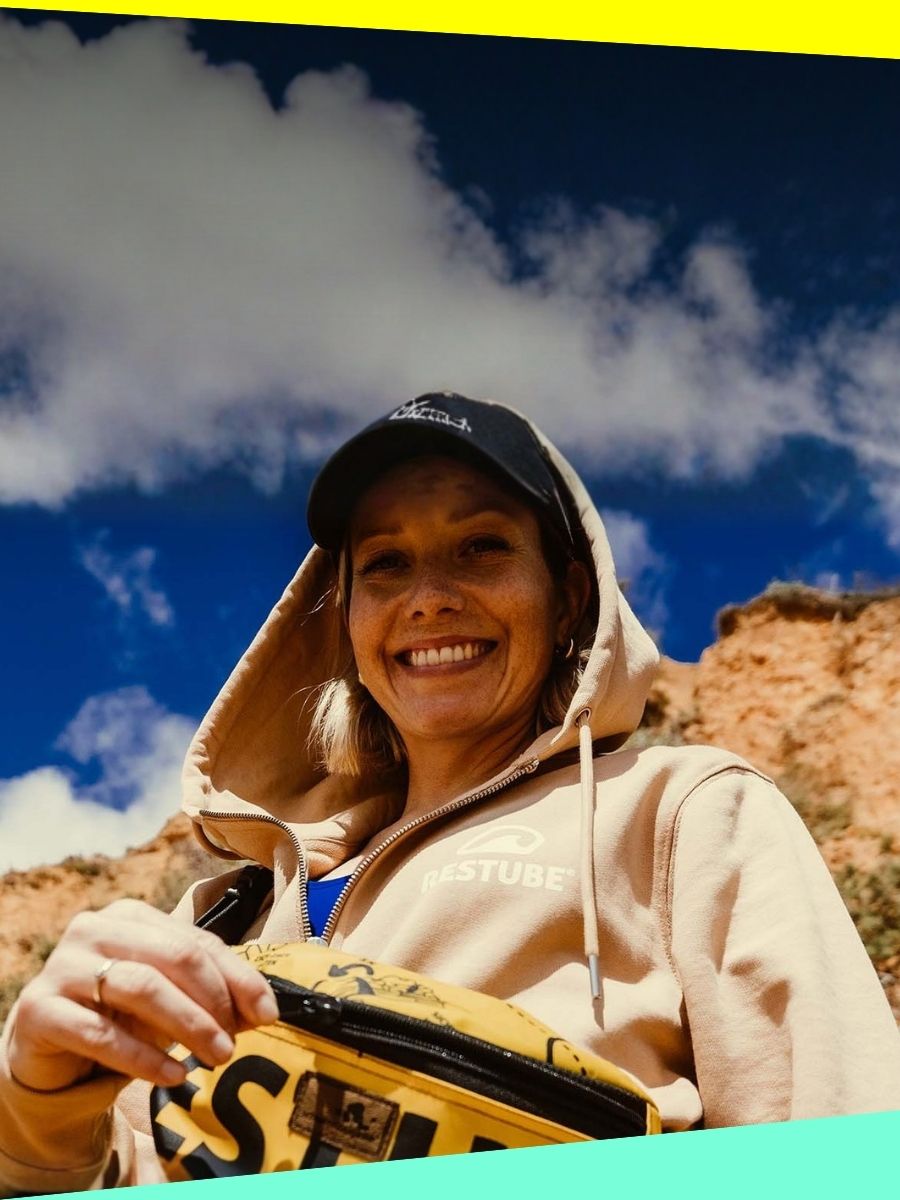 Woman smiling at the camera with a RESTUBE waist pouch – a motivational outdoor moment showing how easy water safety can be.
