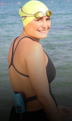 Nathalie Pohl steht im Wasser mit Restube, Schwimmbrille und Badekappe