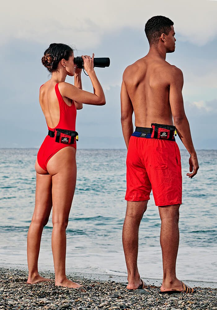 Rettungsschwimmer an der Küste mit Restube Lifeguard beobachten das Meer mit einem Fernglas