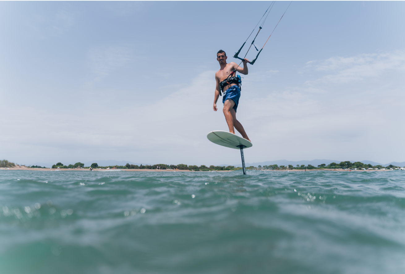 Kite-Surfer schwebt über das Wasser, nur die Finne ist mit dem Wasser in Berührung