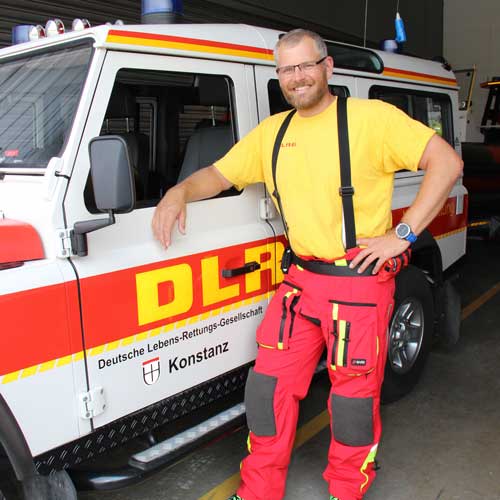 Clemenz Menge von der DLRG Konstanz vor seinem Einsatzfahrzeug, mit Restube lifeguard am Gürtel