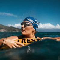 Frau mit aufgeblasener Restube Schwimmboje beim Freiwasserschwimmen