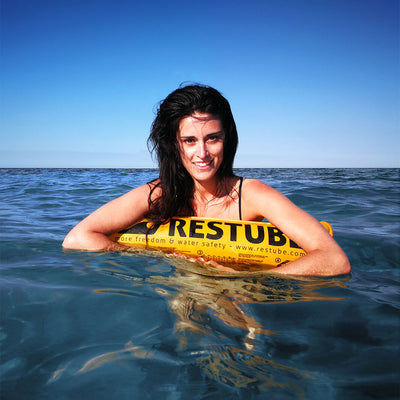 Frau treibt auf dem Wasser, über eine Restube beach gelehnt